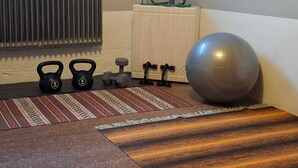 A home gym with kettlebells, dumbbells, a medicine ball, and a yoga mat. - Hassela Ski Vacation Home in Sweden near the lake and ski slopes (Gävleborgs)