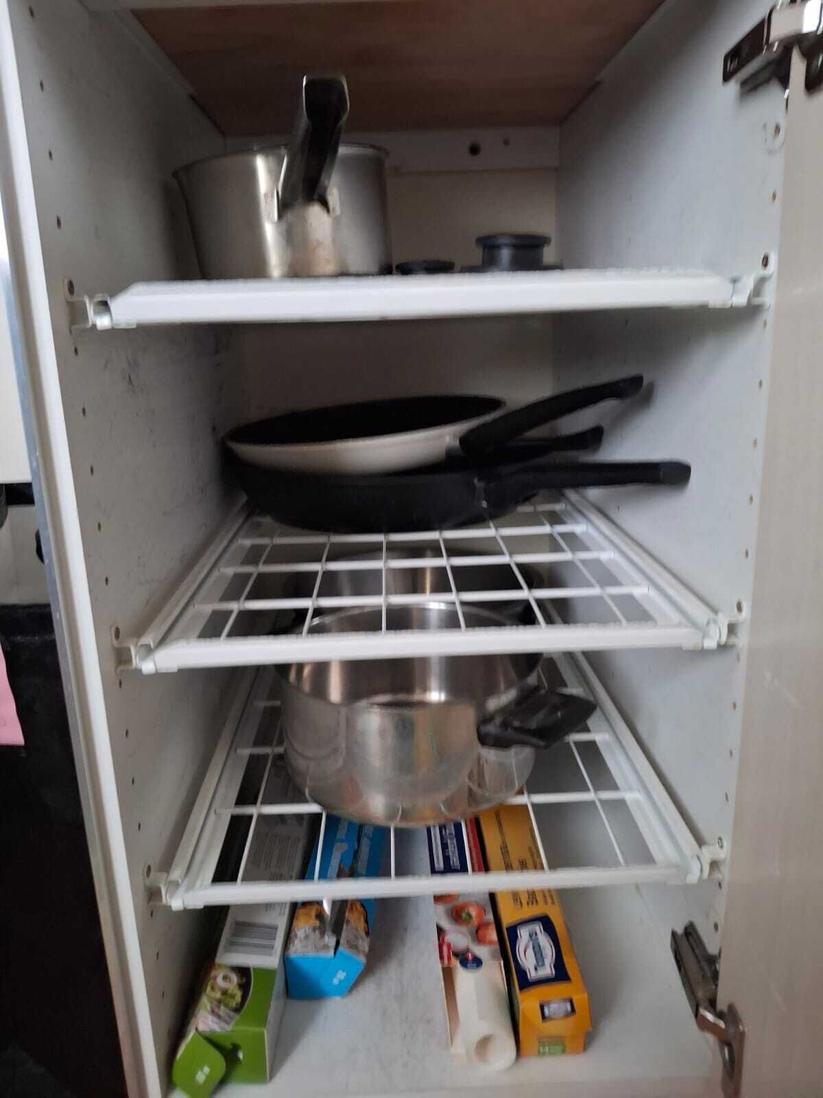 Eine Küche mit Regalen, auf denen Töpfe, Pfannen und Küchenutensilien stehen.