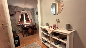A room with a dining area, a mirror, and a shelf with various items. - Hassela Ski Vacation Home in Sweden near the lake and ski slopes (Gävleborgs)