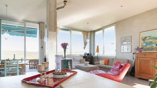 Ein geräumiger Wohnbereich mit Esstisch, Sofa und Blick ins Freie.