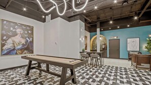 Et moderne kunstgalleri med billardbord, barområde og receptionsdisk.