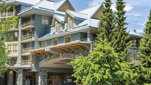 Un edificio a più piani con balconi, facciata in pietra e un cartello con la scritta "Cascade Lodge".