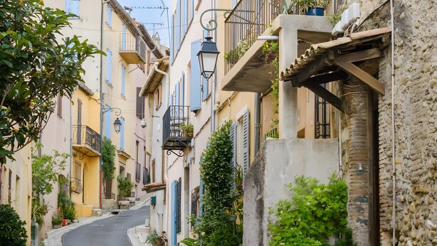 A narrow street with buildings on either side, some with balconies and potted plants. - Double Room with Wi-Fi and Air Conditioning (Cagnes-sur-Mer)