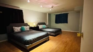 Ein Schlafzimmer mit zwei Betten, Holzboden und einer Decke mit Einbaustrahlern.