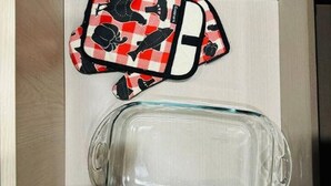 Ein klares Glasgefäß und eine Taschen mit Karomuster in Schwarz und Rot.