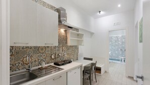 Eine moderne Küche mit Einbauofen, Spüle und Essbereich mit Tisch und Stühlen.