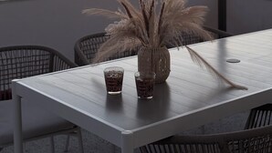 A table with two glasses and a vase on a rooftop terrace with a sunset view. - Casa Lo Bianco sea view apartment in Terrasini (Terrasini)