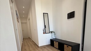 A hallway with wooden flooring, a black console table with baskets, a mirror, and recessed ceiling lights. - Casa Lo Bianco sea view apartment in Terrasini (Terrasini)