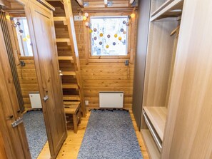 A narrow hallway with wooden walls, a window with a view, and a small staircase. - Kelokaltiokylä mökki 58 by Interhome (Kuusamo)