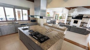 A modern kitchen with a large island, granite countertops, and stainless steel appliances. - Mansión de lujo “La Reina” Llanogrande (Rionegro)