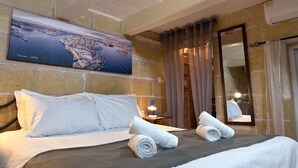 Une chambre d’hôtel avec un lit, une table de chevet, une lampe, un miroir et une grande carte accrochée au mur.