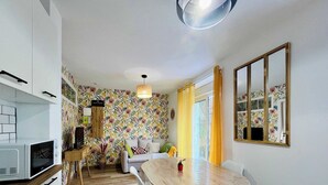 Um espaço compacto com cozinha, área de refeições e sofá.