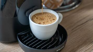 Una macchina per il caffè versa il caffè in una tazza bianca su un piattino nero.