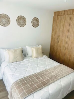 Tabla de planchar con plancha y ropa de cama