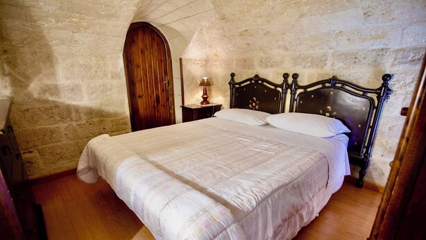 Ein Schlafzimmer mit einem großen Bett, einem Holzkopfende und einem Nachttisch mit Lampe.