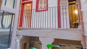 A multi-level building with balconies, a central courtyard, and a view of the surrounding area. - Casa San Carlo Valletta - Azure (Valletta)