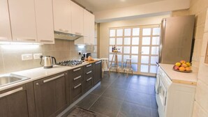 A modern kitchen with dark wooden cabinets, a gas stove, and a stainless steel refrigerator.