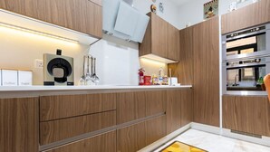 Una cocina moderna con armarios de madera, una cafetera y un horno empotrado.