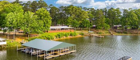 A lakeside property with a dock, a covered pavilion, and a wooden deck.