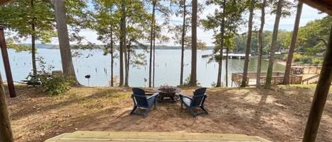 A covered outdoor seating area with a view of a lake and trees.