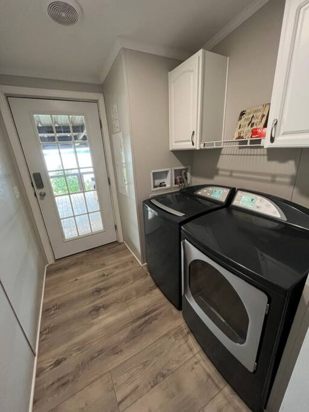 A compact kitchen with a washer and dryer, a microwave, and a small window.