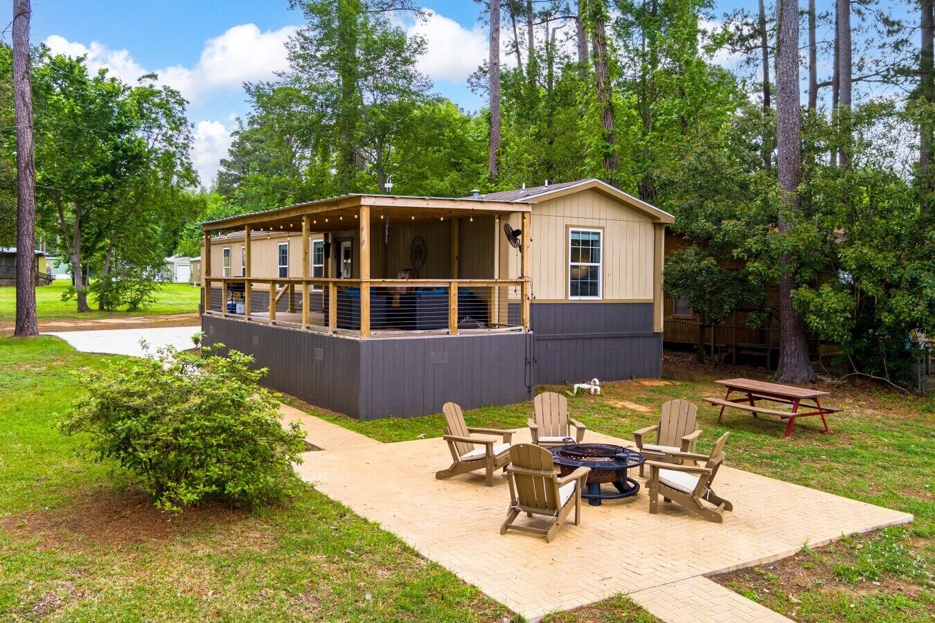 A cabin with a deck, outdoor seating, and a fire pit.