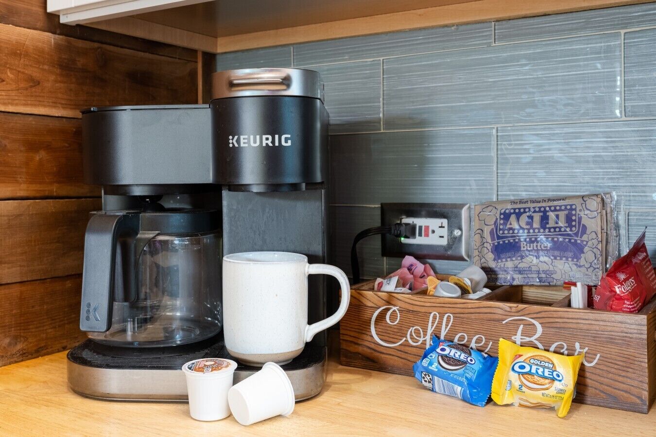 Una cafetera, una taza, dos tazas, una caja con la etiqueta 'Coffee Pot' y dos paquetes de galletas 'Golden Oreo'.