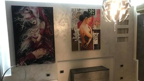 A modern bathroom with a bathtub, a vanity with drawers, and two large wall-mounted artworks. - Elena's house, is a dream retreat for every type of guest (Sannicandro di Bari)