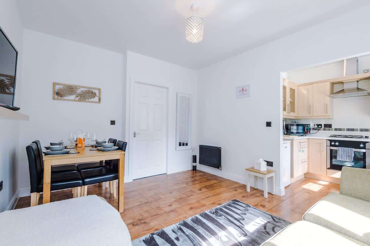 Un espace de vie compact comprenant un coin repas, une kitchenette et un petit coin salon.