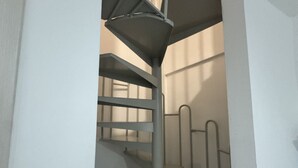 A metal staircase with a handrail and steps, leading to a higher level. - Holiday Properties nei Sassi Home (Matera)