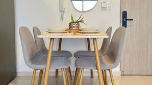 A dining area with a table and four chairs, a decorative mirror, and a sign above the mirror. - Hermoso alojamiento centro (Cartagena)