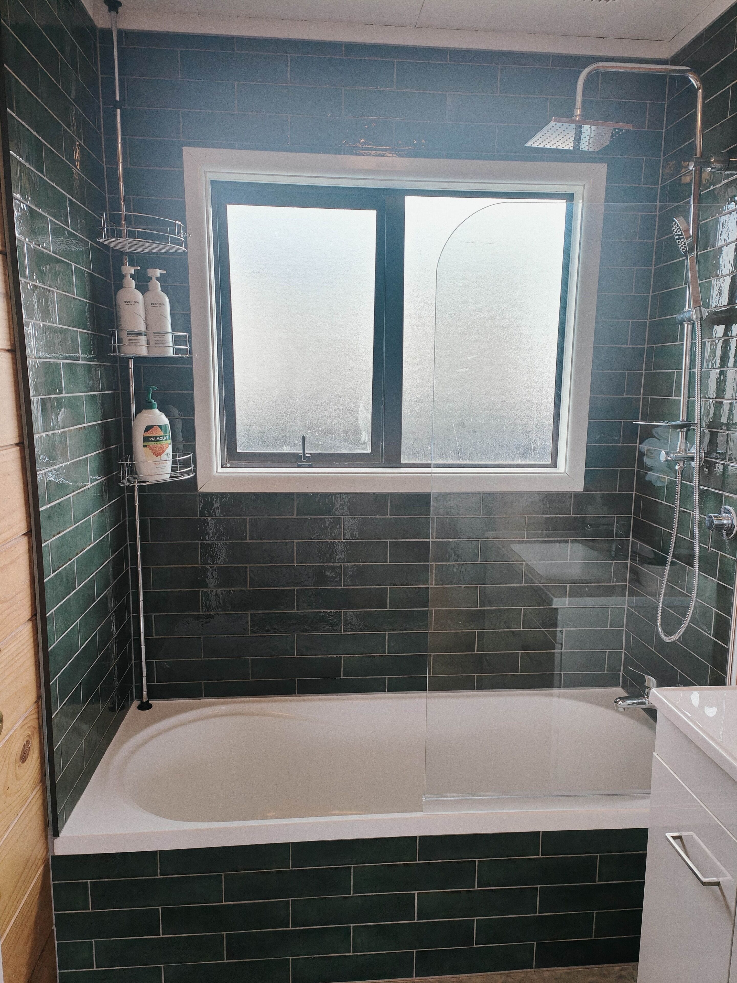 Ein Badezimmer mit Badewanne, Fenster und Dusche.