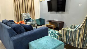 A living room with a sofa, ottoman, armchair, and a ceiling fan. - Cozy 1-bedroom apartment in lovely Castries with AC (Castries)