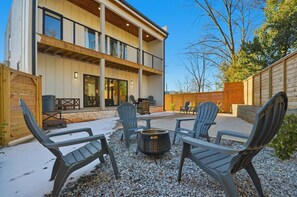 A modern two-story building with a patio area featuring outdoor seating and a fire pit. - Sleeps 10 • New Modern Home by Swamp Rabbit Trail (Greenville)