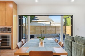 A dining area with a wooden table, chairs, and a potted plant. - Sleeps 10 • New Modern Home by Swamp Rabbit Trail (Greenville)