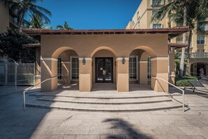 A building with a beige facade, arched entrance, and a tiled roof. - Stylish 2BR/2BA Getaway - Pool, Tennis Court & Free Parking (Aventura)