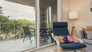 Un balcón con una silla, una mesa y una lámpara.