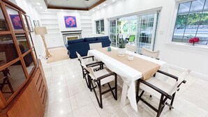 Un espace repas comprenant une longue table, des chaises et un ventilateur de plafond.