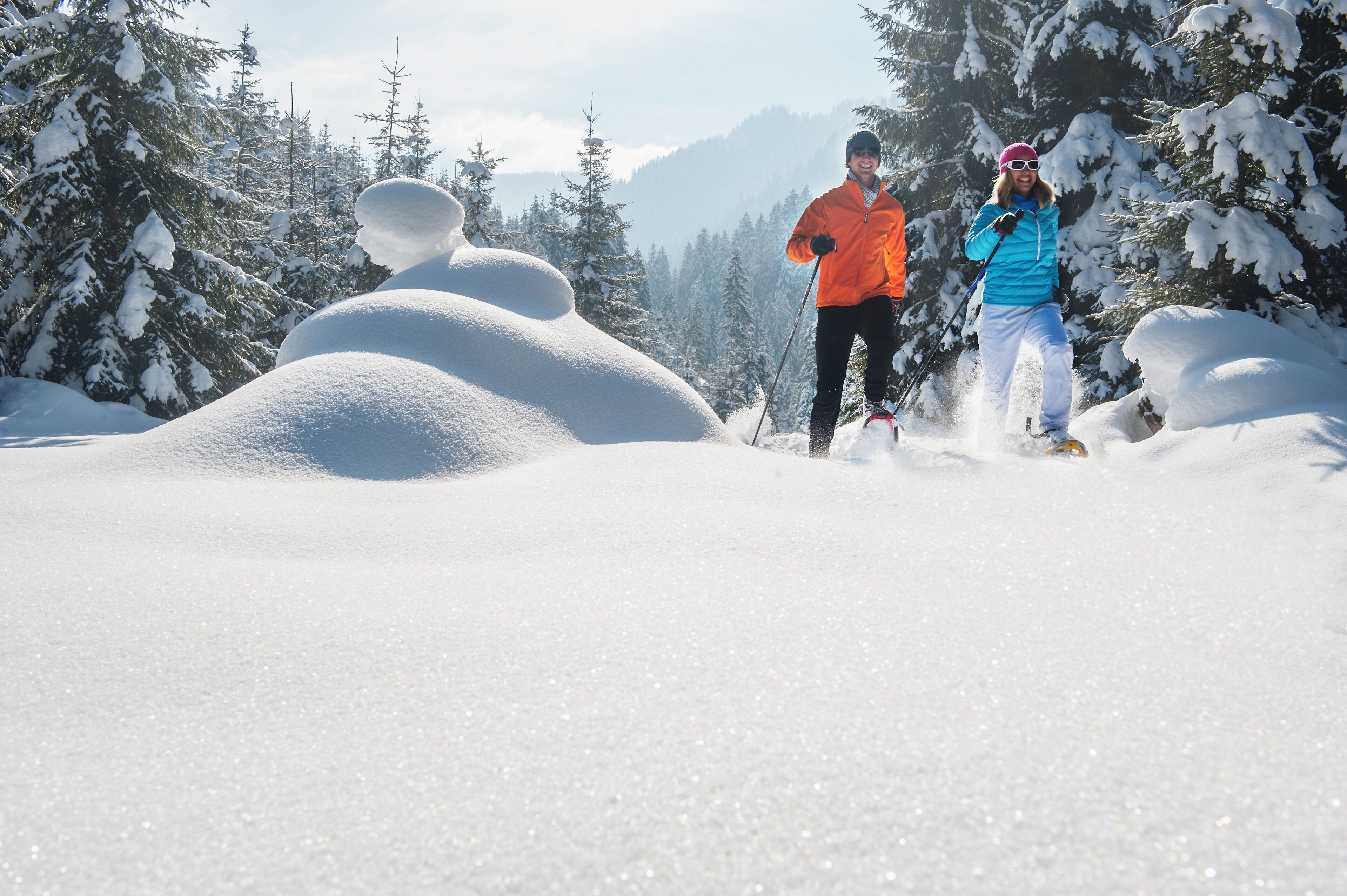 A snowy landscape with two people skiing.