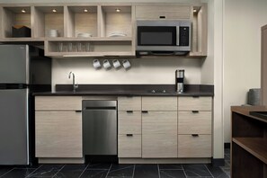 Una cocina moderna equipada con lavavajillas, microondas y refrigerador de acero inoxidable.