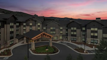 A multi-story hotel with a central courtyard and a parking area.