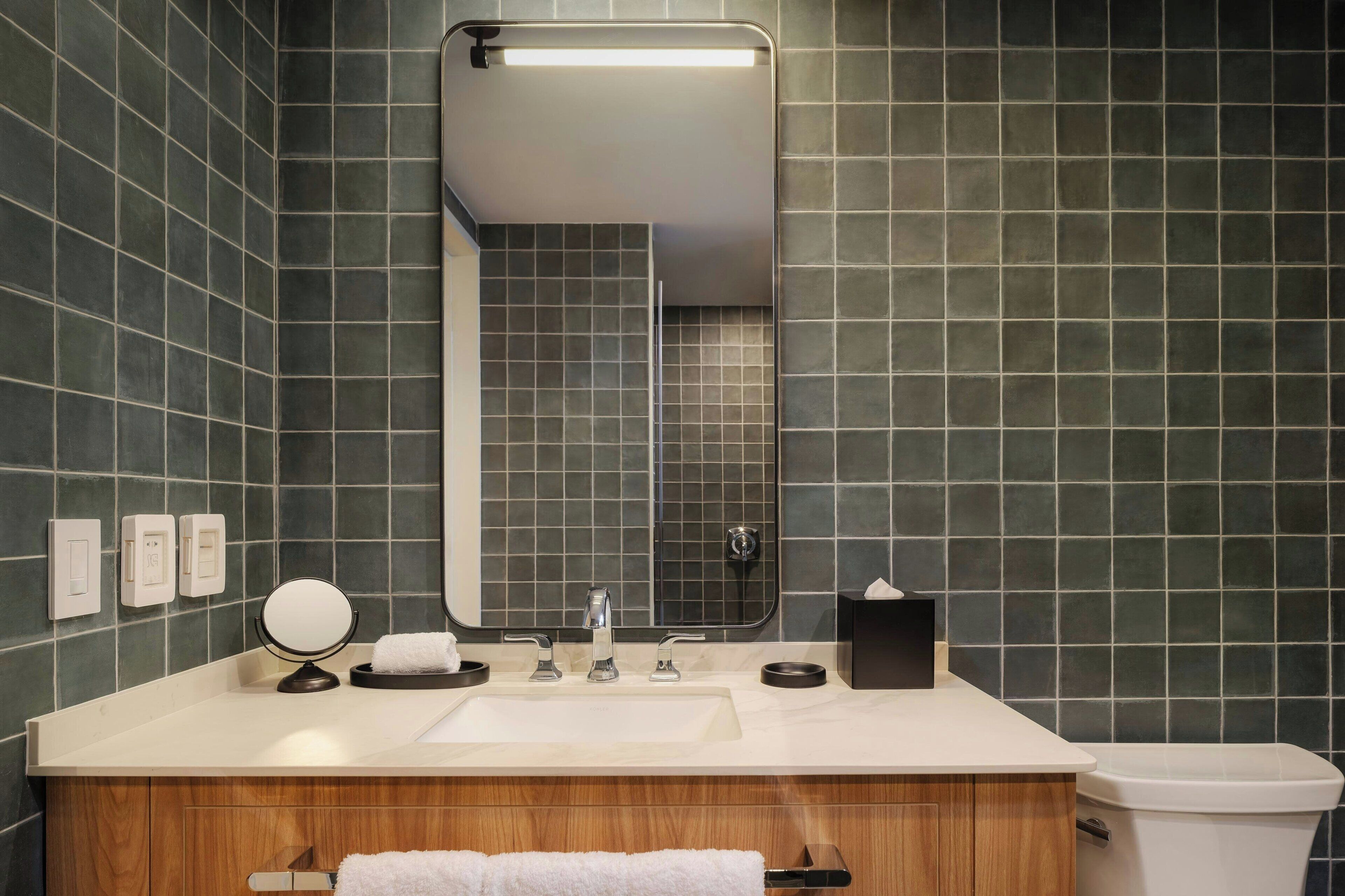 A bathroom with a sink, mirror, and toilet.