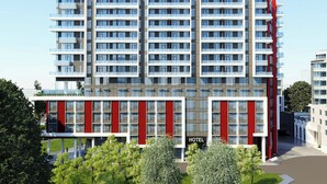 A multi-story hotel with a modern architectural design, featuring a prominent red and white facade, large windows, and a central entrance. - Le Méridien Richmond Pinnacle Hotel (Richmond)