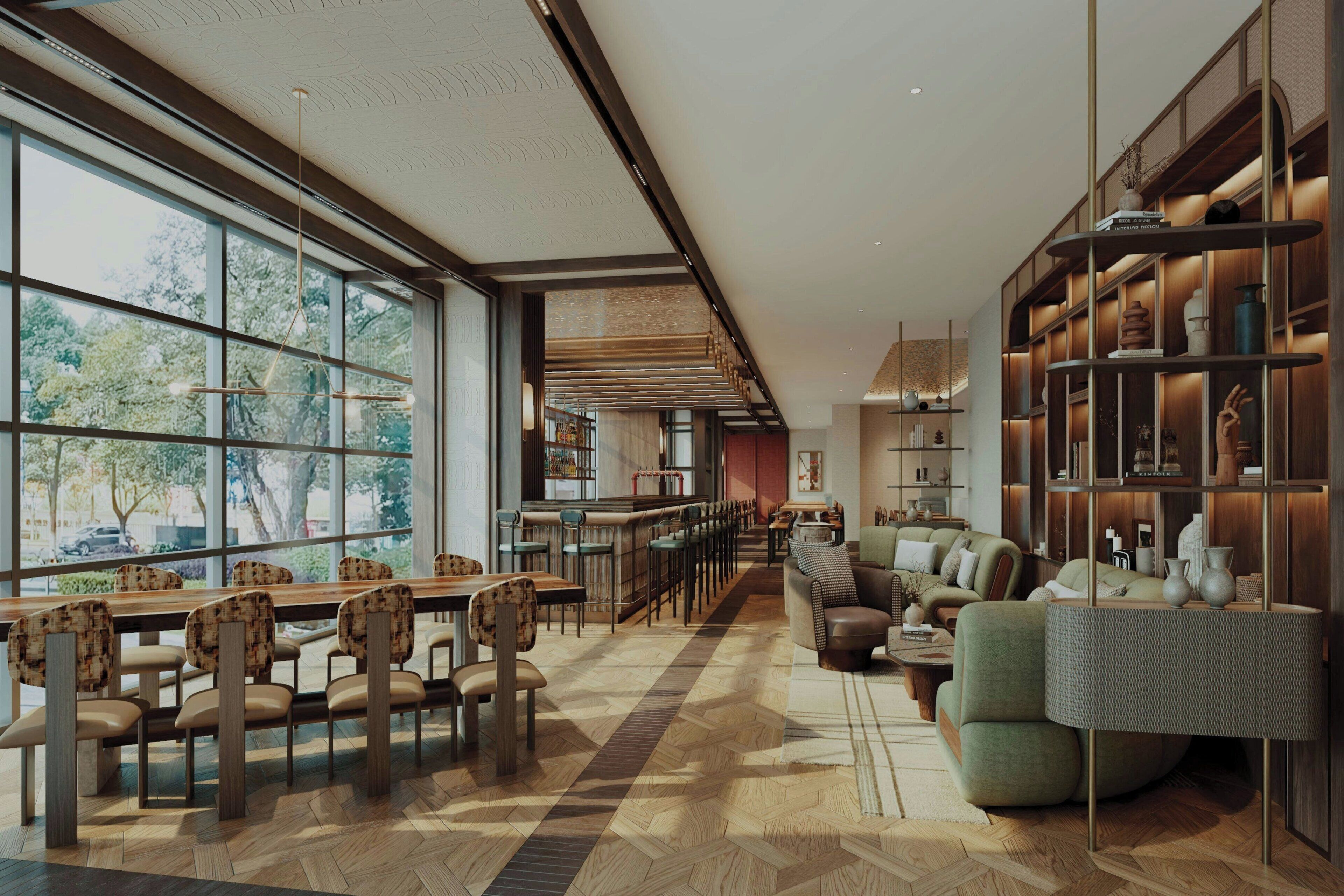 A spacious, modern interior with a long dining area, comfortable seating, and a large bookshelf.
