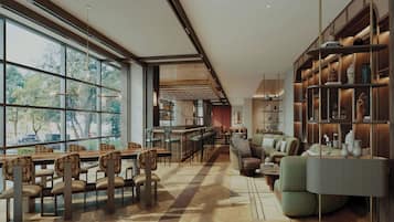 A spacious, modern interior with a long dining area, comfortable seating, and a large bookshelf.