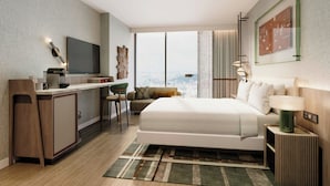 A modern hotel room with a large bed, a desk with a flat-screen TV, a view of the city, and a large window. - Le Méridien Richmond Pinnacle Hotel (Richmond)