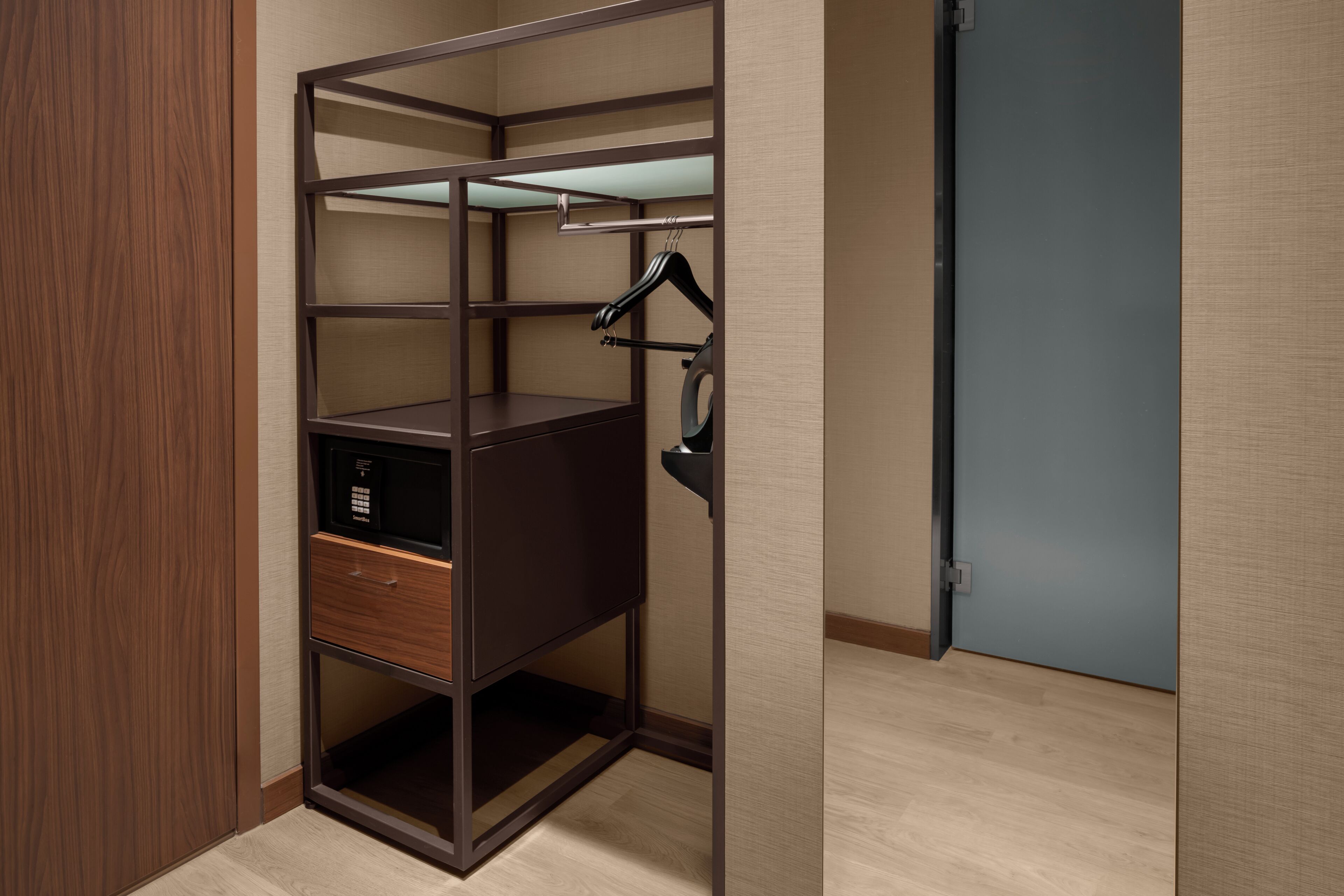 A walk-in closet with open shelving, a hanging rod, and a microwave.