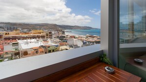 A balcony with a view of a coastal cityscape, including buildings and the sea. - 3BR Ocean Sunset Suite Las Canteras (Las Palmas de Gran Canaria)