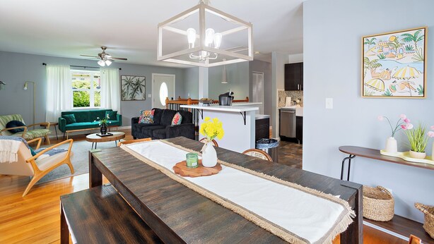 A modern living room with a dining area, a ceiling fan, and a kitchen in the background. - Spacious 5-bedroom Tallahassee Home / Minutes to FSU & FAMU & The Capitol (Tallahassee)