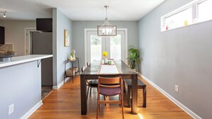 A modern kitchen with a central island, a dining area with a wooden table and chairs, and a view into the dining room. - Spacious 5-bedroom Tallahassee Home / Minutes to FSU & FAMU & The Capitol (Tallahassee)